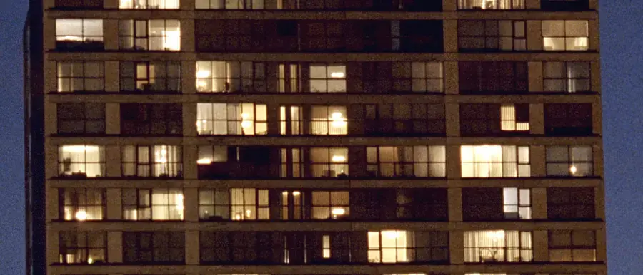 A grid of lit apartment windows in Sacramento at night, most warm, some dark